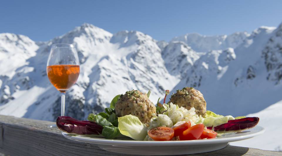Knödel und Wein mit Panoramablick auf Berge in Sulden am Ortler