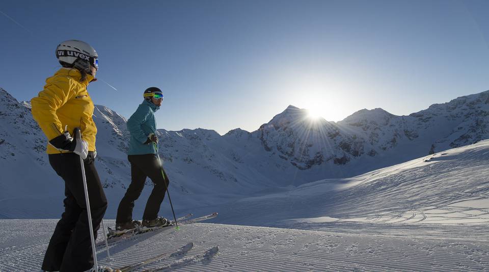 Skifahrer stehen zwischen Bergen in Sulden am Ortler